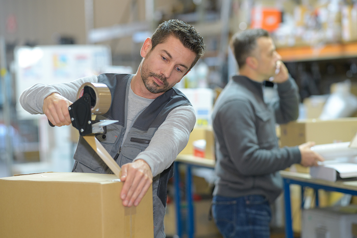 Warehouse worker taping a box Manufacturing Shipping Solution